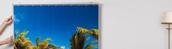 Bedruckter Lamellenvorhang in Benutzung vor dem Fenster bedruckt mit Palmen und Meer